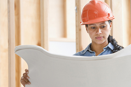 Female construction worker looking at blueprints